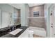 Bathroom with a bathtub, vanity with dark countertop, and tiled walls at 8374 Agate St, Port Charlotte, FL 33981