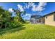 Spacious backyard with grassy lawn and screened pool enclosure at 8374 Agate St, Port Charlotte, FL 33981