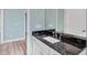 Vanity with dark countertop and white sink in a light-colored bathroom at 8374 Agate St, Port Charlotte, FL 33981