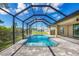 Screened-in pool and patio area with gray pavers at 8374 Agate St, Port Charlotte, FL 33981
