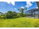 Landscaped backyard with grassy lawn and screened pool enclosure at 8374 Agate St, Port Charlotte, FL 33981