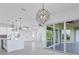 Open living space with sliding glass doors and a modern chandelier at 15715 Viscount Cir, Port Charlotte, FL 33981
