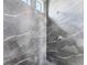 Modern shower with gray marble tile and pebble floor at 15715 Viscount Cir, Port Charlotte, FL 33981