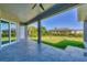 Covered patio with glass doors leading to the inside, overlooking the grassy backyard at 15715 Viscount Cir, Port Charlotte, FL 33981