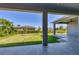 View of the backyard from under the covered patio, showing a grassy lawn at 15715 Viscount Cir, Port Charlotte, FL 33981