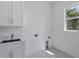 Laundry room with white cabinets and a sink at 15715 Viscount Cir, Port Charlotte, FL 33981