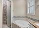 Spa-like bathroom featuring a soaking tub and a walk-in shower with mosaic tile at 249 Rotonda Cir, Rotonda West, FL 33947