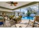 Relaxing poolside patio with wicker furniture and screened enclosure at 7168 Lighthouse St, Englewood, FL 34224