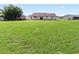 Spacious backyard with grassy area and partial home view at 6367 Facet Ln, Port Charlotte, FL 33981
