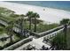Elevated boardwalk winding through tropical landscape, leading to sandy beach and ocean views at 13342 Commonwealth Ave, Port Charlotte, FL 33981