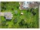 Expansive property with a house, large yard, and a storage shed, surrounded by lush greenery and a partially constructed building nearby at 13401 Galveston Ave, Port Charlotte, FL 33981