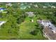 An aerial view of the property, highlighting the vast backyard with a shed and surrounding greenery at 13401 Galveston Ave, Port Charlotte, FL 33981