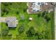 An aerial view of the home, showing the large lot and surrounding trees and a construction site nearby at 13401 Galveston Ave, Port Charlotte, FL 33981