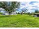 Large backyard featuring a lush green lawn, mature trees, and an inviting outdoor space at 13401 Galveston Ave, Port Charlotte, FL 33981