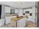 Bright kitchen features white cabinets, modern appliances, an island with wood top, and light-colored hardwood floors at 13401 Galveston Ave, Port Charlotte, FL 33981