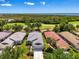 Aerial view displays property near golf course and lake. The property features a gray roof and meticulous landscaping at 3359 Osprey Ln, Port Charlotte, FL 33953