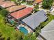This aerial shows a property with a pool, screened in patio, tile roofs, and luscious lawn at 3359 Osprey Ln, Port Charlotte, FL 33953