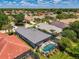 Bird's-eye view highlighting the home's tile roof, screened-in pool, and lush landscaping at 3359 Osprey Ln, Port Charlotte, FL 33953