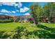 A beautiful green backyard features a screened lanai, lush lawn, and mature trees at 3359 Osprey Ln, Port Charlotte, FL 33953