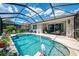 Sparkling swimming pool enclosed in a screened lanai, surrounded by lush landscaping and comfortable seating areas at 3359 Osprey Ln, Port Charlotte, FL 33953
