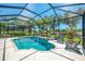Inviting pool surrounded by a screened enclosure and lush greenery providing a private oasis for relaxation at 3359 Osprey Ln, Port Charlotte, FL 33953