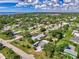 Panoramic aerial view of homes surrounded by lush greenery with glimpses of the water in the distance at 797 Michigan Ave, Englewood, FL 34223