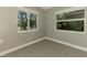 Well-lit bedroom with neutral carpet, two windows, and ample natural light at 797 Michigan Ave, Englewood, FL 34223