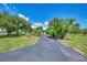 Home with a long driveway surrounded by beautiful landscaping with a well-maintained lawn at 797 Michigan Ave, Englewood, FL 34223
