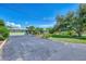 Charming home with a long blacktop driveway, mature landscaping, and a well-maintained lawn at 797 Michigan Ave, Englewood, FL 34223