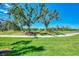 Landscaped green golf course with mature trees and pathway at 3359 Osprey Ln, Port Charlotte, FL 33953