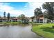 Condos with pond, lush landscaping, and partial lake view at 504 Pine Hollow Cir # 504, Englewood, FL 34223