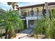 Exterior view of condo building with walkway and tropical landscaping at 504 Pine Hollow Cir # 504, Englewood, FL 34223