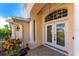 Elegant entryway with double doors and decorative glass, columns and landscaping at 247 Tournament Rd, Rotonda West, FL 33947