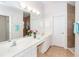 Bright bathroom with double vanity, large mirror, and shower at 8216 Parkside Dr, Englewood, FL 34224