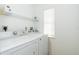 Bright laundry room with washer, dryer, and shelving at 8216 Parkside Dr, Englewood, FL 34224
