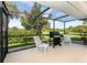Enjoy outdoor dining in this screened patio with a grill and view of the backyard at 8216 Parkside Dr, Englewood, FL 34224