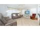 Spacious living room featuring comfortable sofas, a TV, and a rocking chair at 8216 Parkside Dr, Englewood, FL 34224