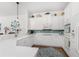 White kitchen with teal backsplash and appliances at 11100 Hacienda Del Mar Blvd # 202, Placida, FL 33946