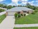 Single-story home with a gray roof and a well-maintained lawn at 7506 Spinnaker Blvd, Englewood, FL 34224