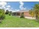 Large backyard with grass, patio, and tropical landscaping at 7506 Spinnaker Blvd, Englewood, FL 34224