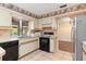 Kitchen offers white cabinets, tile floors, and stainless steel appliances at 7506 Spinnaker Blvd, Englewood, FL 34224