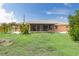 House's backyard with grass, screened porch and tropical plants at 7506 Spinnaker Blvd, Englewood, FL 34224