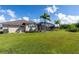Backyard view showing a house with a screened pool and patio at 15507 Aqua Cir, Port Charlotte, FL 33981