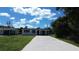 Single-story home with white exterior and a long driveway at 317 E Green St, Englewood, FL 34223