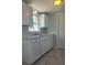 White kitchen cabinets, grey tile floors, and a window overlooking the backyard at 317 E Green St, Englewood, FL 34223
