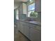 White cabinets and countertops, grey tile floors, and stainless steel appliances at 317 E Green St, Englewood, FL 34223