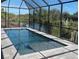 Enclosed rectangular pool with paver deck and canal view at 13342 Commonwealth Ave, Port Charlotte, FL 33981