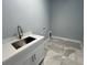 Laundry room with utility sink and white cabinets at 13342 Commonwealth Ave, Port Charlotte, FL 33981