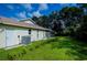 Landscaped backyard with grassy area and AC unit at 122 Swan Dr, Rotonda West, FL 33947