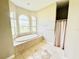 Relaxing bathroom with soaking tub, shower, and tile flooring at 324 Santurce Ave, North Port, FL 34287